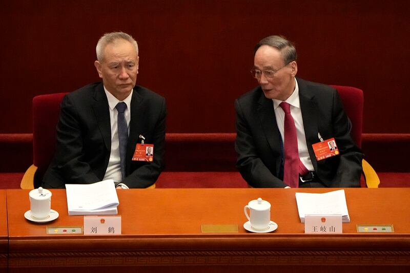 中共中央政治局委员、国务院副总理、金融委主任刘鹤(左)出席2022年3月5日举行的人大会议(美联社)