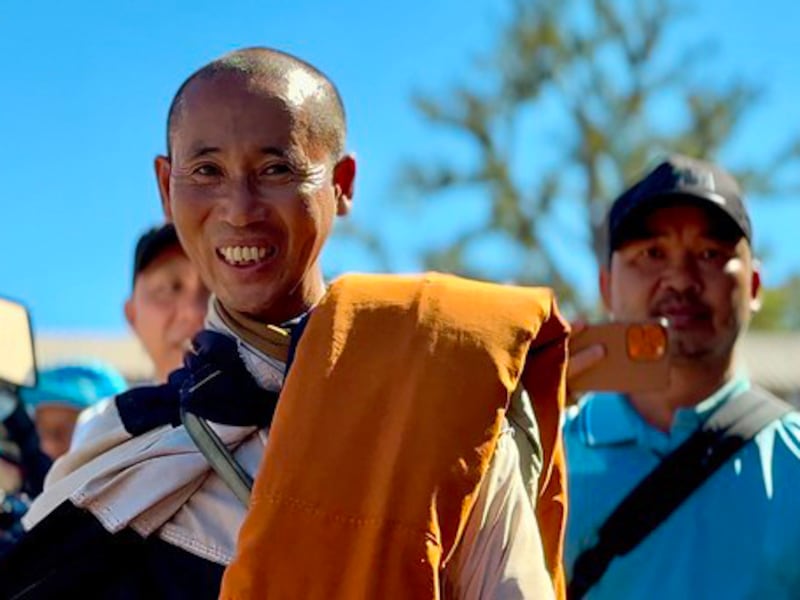 Vietnamese monk Thich Minh Tue is followed by his bodyguard Doan Van Bau, right, as he walks through Thailand on his way to India, in January 2025.