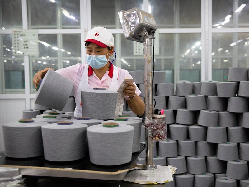 A worker packages spools of cotton yarn in an Aksu factory in China's Xinjiang Uyghur Autonomous Region, April 20, 2021.