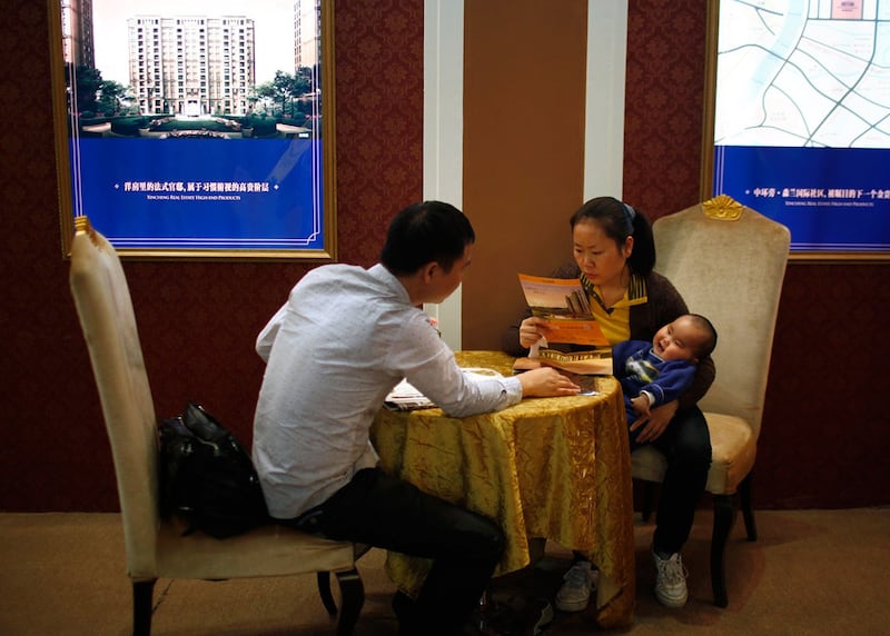 一对夫妇在上海2012年春季房地产展会上阅读宣传材料。(路透社)