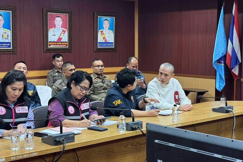 2025年1月7日,中国演员王星(右)在泰缅边境达府湄索区与泰国警察交谈。