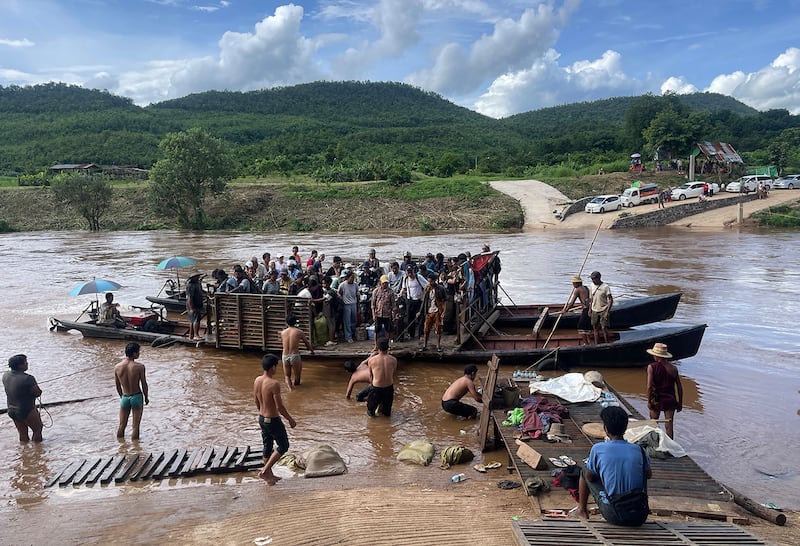 Displaced people from Lashio cross the Dokhtawaddy river as they flee their homes following clashes between Myanmar's military and the Ta'ang National Liberation Army (TNLA), in Zin Ann village between Lashio and Hsipaw township in Myanmar's northern Shan state, July 8, 2024