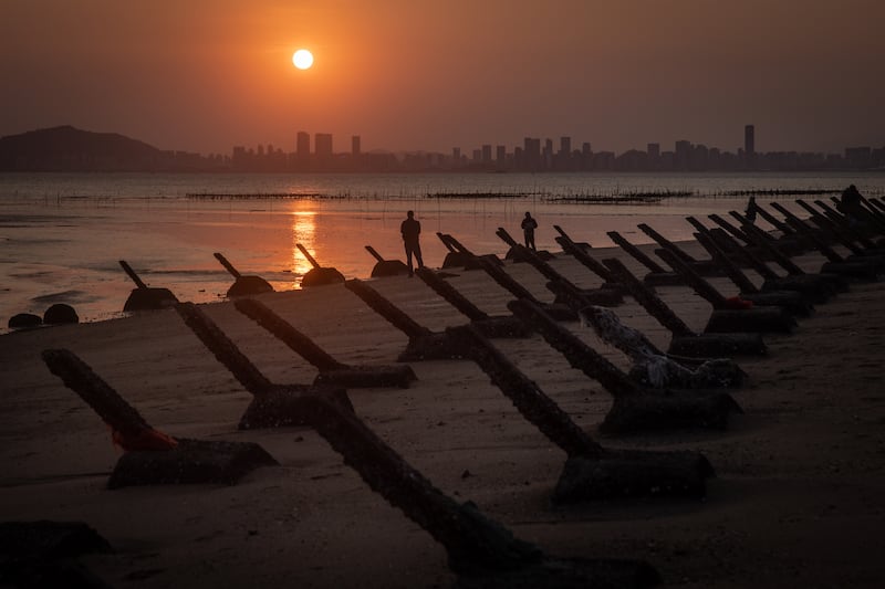 The sun sets over the Chinese city Xiamen as seen from anti-tank fortifications on April 9, 2023 on Kinmen, Taiwan.