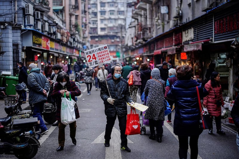 2020年12月7日,湖北省武汉市,新冠病毒爆发近一年后,一名男子在街上推销房子。(路透社)