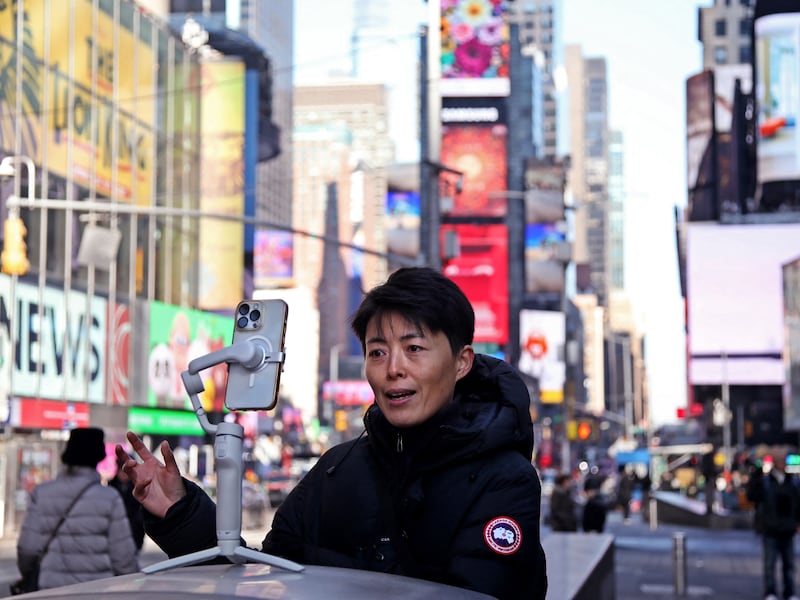 A woman records herself for social media in Times Square in New York City, Jan. 17, 2025.