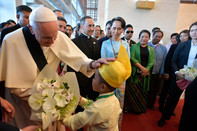 Pope Francis, with Aung San Suu Kyi, center, receives flowers in Naypyidaw, Myanmar, Nov. 28, 2017.